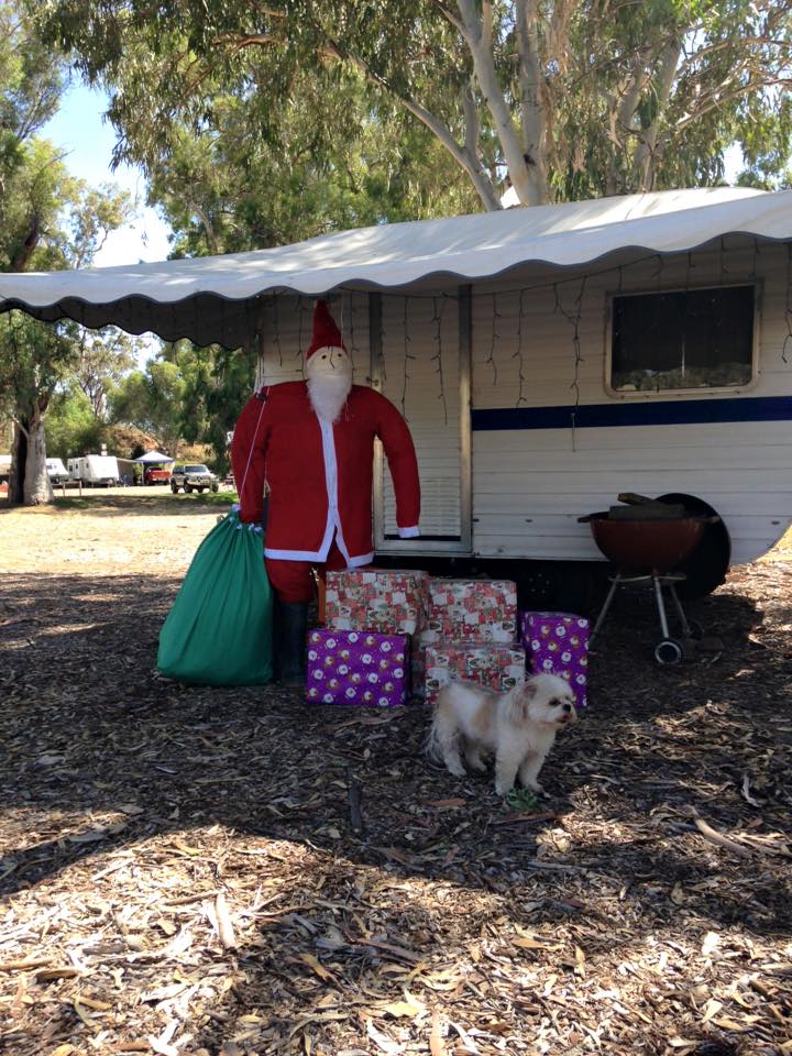 Santa with presents in front of caravan
