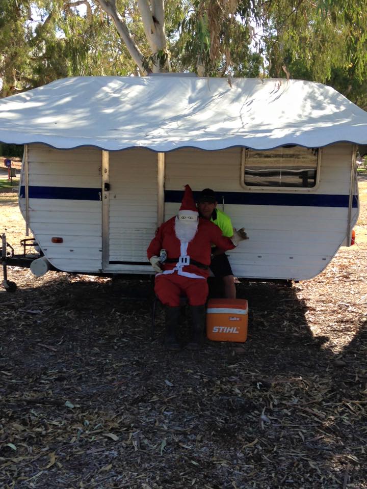Santa sitting in front of a caravan